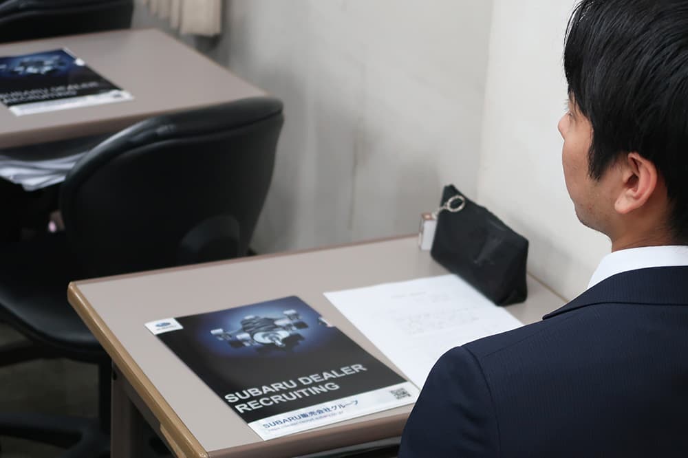 スバルの「安心と安全」の理念についての話に集中する学生たち。机上のクリアファイルが印象的な一コマ